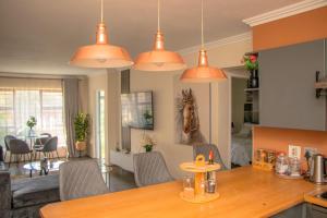 a kitchen and living room with orange pendant lights at Villa Elizabeth - Fourways Gardens Sandton in Fourways