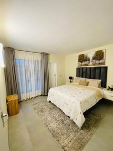 a large bedroom with a large bed and a rug at Villa Elizabeth - Fourways Gardens Sandton in Fourways