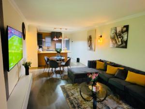 a living room with a couch and a tv in it at Villa Elizabeth - Fourways Gardens Sandton in Fourways