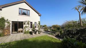 a white house with a yard with a lawn at Rodeen Country House in Castletownbere