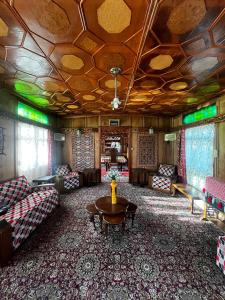 a living room with couches and a table in a room at Houseboat Nightingale in Srinagar