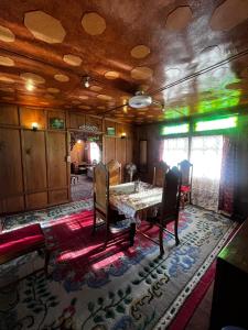 a dining room with a table and chairs on a rug at Houseboat Nightingale in Srinagar