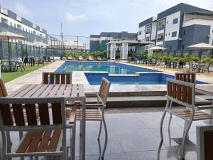 a patio with a table and chairs and a pool at D'Crown Place in Abuja
