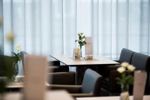 ein Tisch mit einer Blumenvase darauf in der Unterkunft Hella Globe in Lippstadt