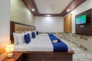 a bedroom with a large bed and a flat screen tv at Hotel Kanha in Haridwār