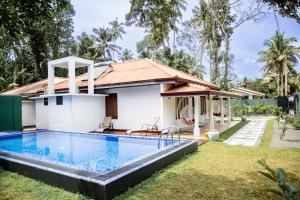 a villa with a swimming pool and a house at Villa Hatange in Weligama