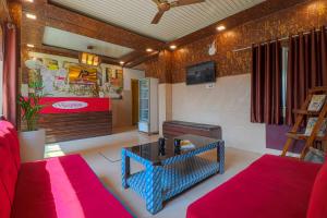 a living room with a red couch and a table at Hotel Kanha in Haridwār