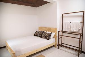 a small bedroom with a bed and a mirror at Villa Hatange in Weligama