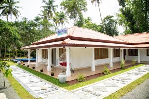 a house with a porch and a swimming pool at Villa Hatange in Weligama