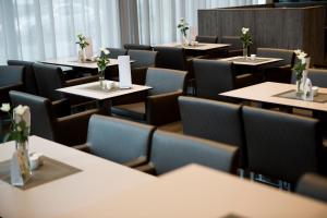 ein Esszimmer mit Tischen und Stühlen, die mit Blumen geschmückt sind in der Unterkunft Hella Globe in Lippstadt