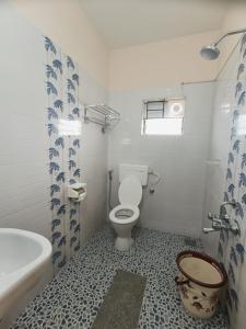 a bathroom with a toilet and a tub and a sink at Comfort nest in Manipal in Manipal