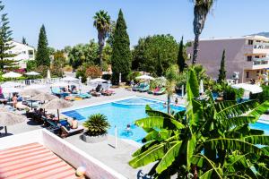 a pool at a hotel with people sitting around it at Premium ikaros in Laganas