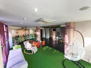 a room with a green floor and a room with a swing at Melaka City Hotel in Malacca