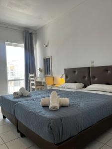 a bedroom with a large bed with towels on it at Premium ikaros in Laganas +8 photos