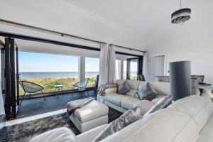 a living room with a couch and a view of the ocean at Washington Beach House with Lodge in Heacham
