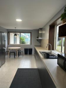 a kitchen with a sink and a table in it at Barcelos Residence Living in Barcelos