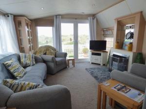 a living room with two couches and a television at Washington Beach House with Lodge in Heacham