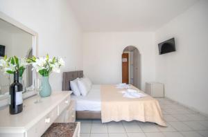 a bedroom with a bed and a vase of flowers at Premium ikaros in Laganas