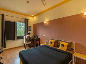 a man sitting at a desk in a hotel room at The Hosteller Delhi in New Delhi