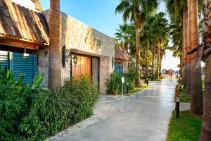 a sidewalk next to a building with palm trees at Royal Garden Beach Hotel in Konaklı
