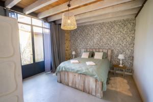 a bedroom with a wooden bed and a chandelier at Le refuge in Marsalès +28 photos