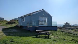 a blue house with a picnic table in front of it at D20 Glendon, Riviere Towans in Hayle