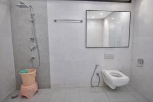 a bathroom with a shower and a toilet and a mirror at Mauryan Elite Hotel Vasant Kunj in New Delhi