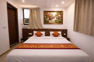 a bedroom with a large white bed with two pillows at Mauryan Elite Hotel Vasant Kunj in New Delhi
