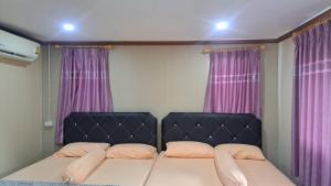 a bed in a room with purple curtains at Ban Roi Pah in Ban Khlong Si +9 photos