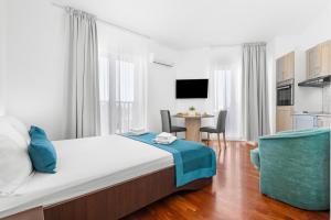 a bedroom with a bed and a table with chairs at LotusApart in Premantura