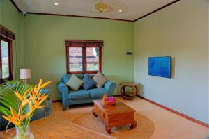 a living room with a couch and a coffee table at Chalok Reef Divers Hostel in Ko Tao