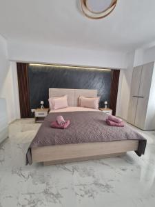 a bedroom with a large bed with pink pillows on it at Little Escape in Brăila