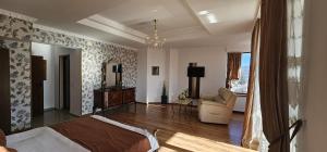 a bedroom with a bed and a living room at Karmia Boutique in Piatra Neamţ +32 photos