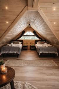 a attic bedroom with two beds and a window at Gajówka in Istebna +23 photos