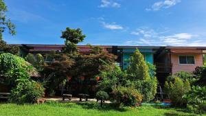 a house with two benches in a yard at Ban Roi Pah in Ban Khlong Si