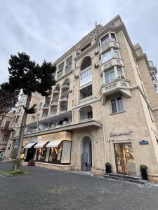 a large stone building with a store on a street at Mayden Tower apartment in Baku