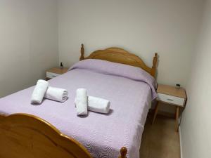 a bed with two rolled towels on top of it at BERMUDAS-TURIS Apartamentos in Benidorm +82 photos