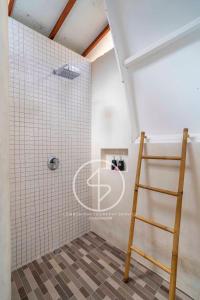 a ladder in a bathroom with white tiles at Ings Garden Acommodation in Gili Islands