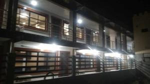 a building with a bunch of windows at night at Pacifico's Hostel in Barili