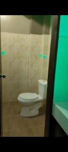 a bathroom with a white toilet in a room at Pacifico's Hostel in Barili