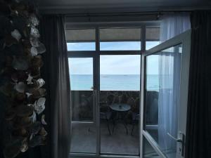 a view of the ocean from a room with a window at Touch the Coast in Batumi +2 photos