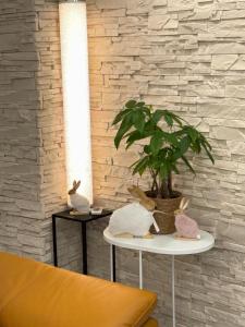 a table with a potted plant on it next to a wall at Alia house with garden in Piešťany in Piešťany