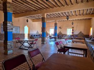a dining room with tables and chairs in a building at Auberge camping la tradition in Merzouga