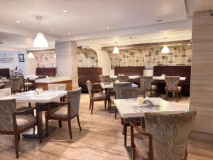 a dining room with tables and chairs and tablesktop at Hiltop Hotel in Mumbai