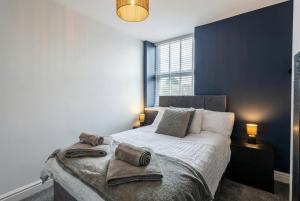 a bedroom with a large bed with towels on it at Brontë Country 4 Bed Retreat with Fireplace in Oakworth