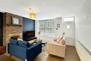 a living room with a blue couch and a fireplace at Brontë Country 4 Bed Retreat with Fireplace in Oakworth