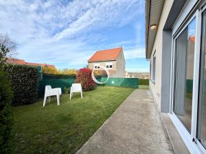 two white chairs sitting in the yard of a house at GC - La Voile Bleue in Wissant