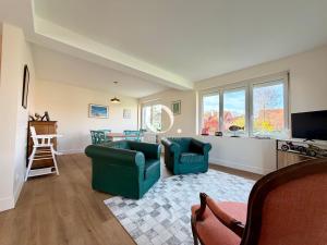 a living room with two chairs and a tv at GC - La Voile Bleue in Wissant