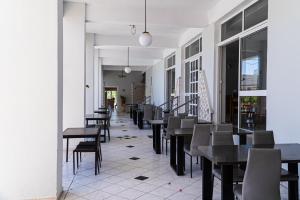 a corridor with tables and chairs in a restaurant at Premium ikaros in Laganas