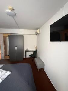 a room with a bed and a tv on a wall at hotel Diana in Murska Sobota